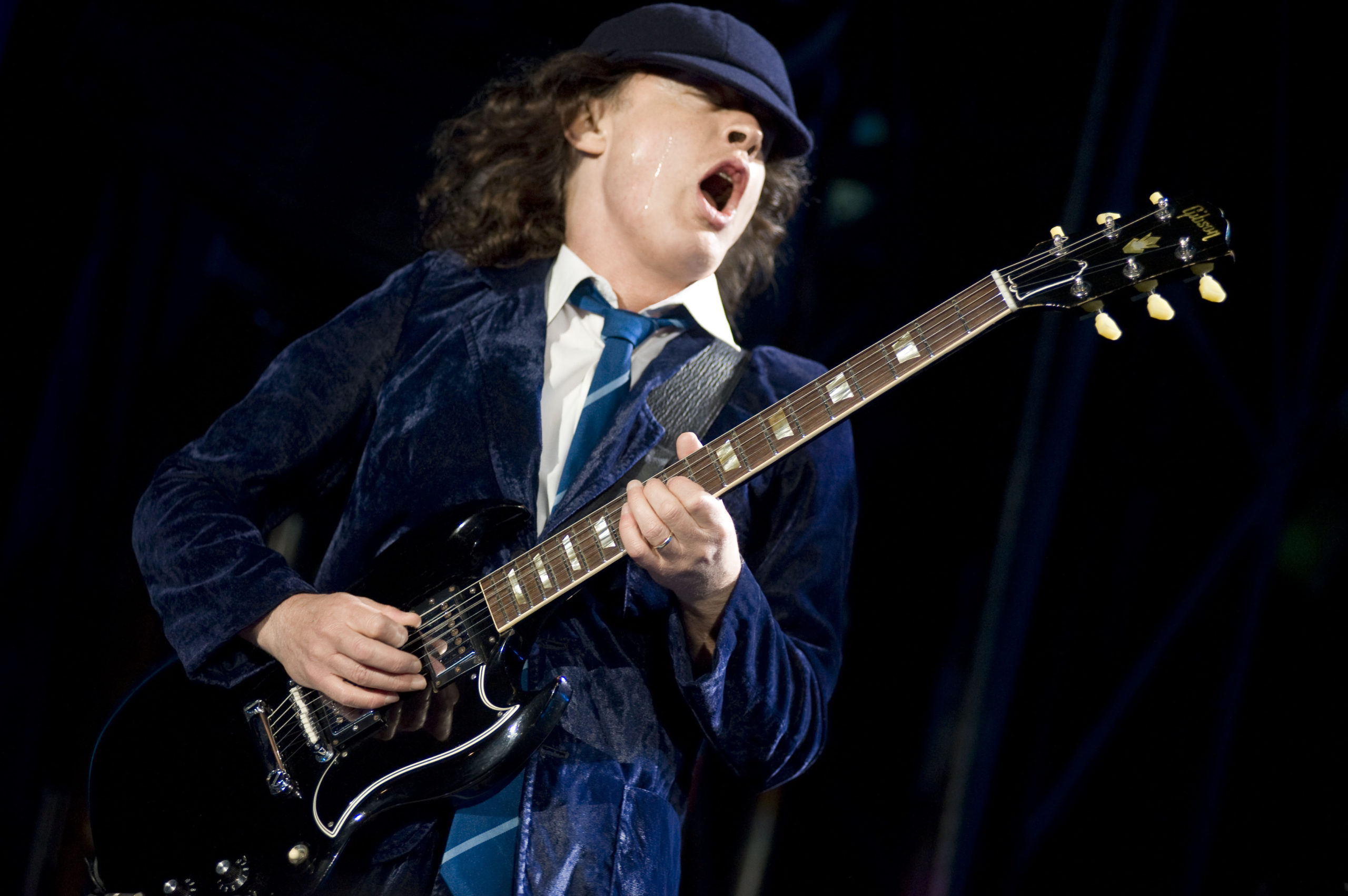 Гитарист янг. Гитарист AC DC Ангус. AC DC Angus young Guitar. Angus young AC/DC 2022.